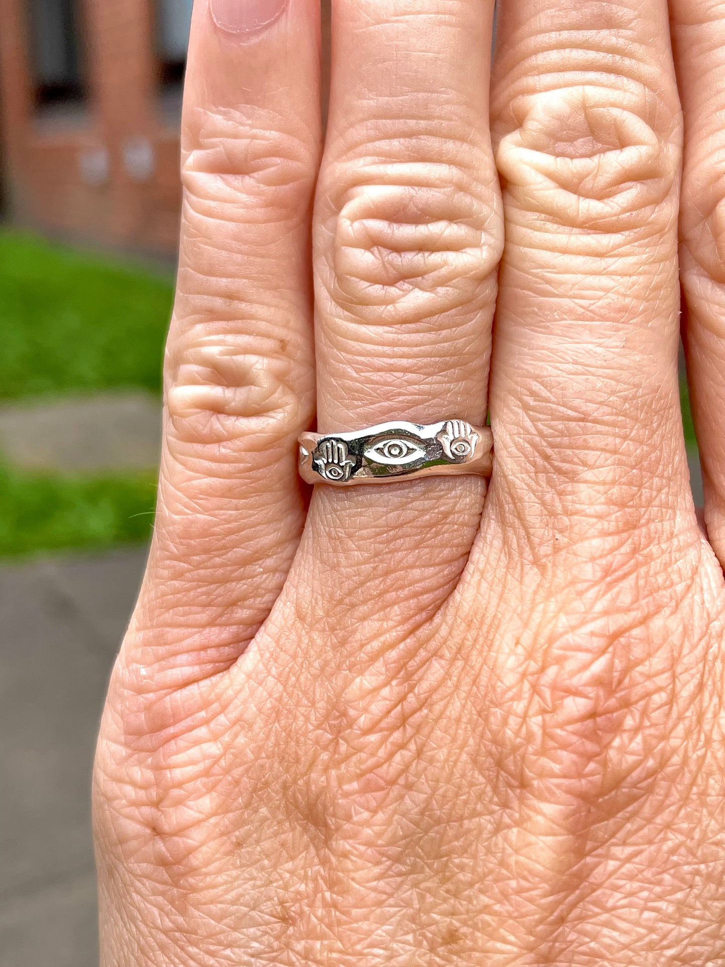 Eye and hamsa band ring worn on hand – handmade in sterling silver