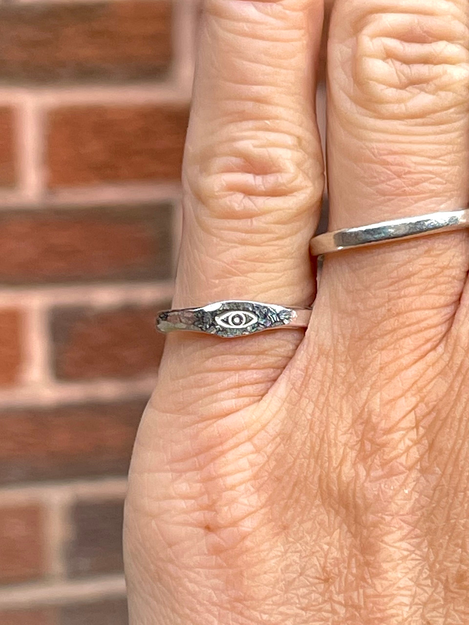 Sterling silver eye pinky ring worn on finger, delicate and minimal